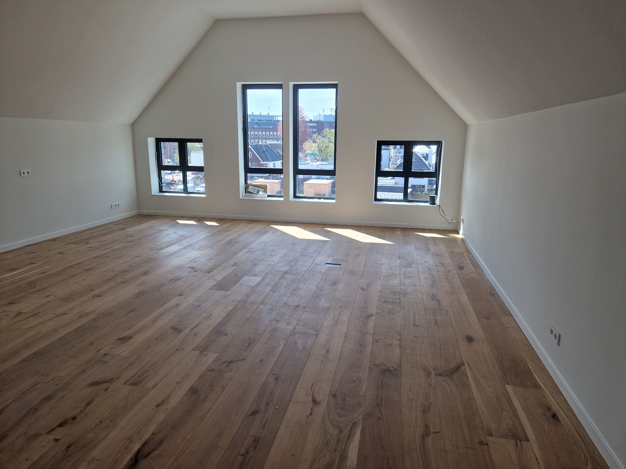 Brede houten planken in een lichte zolderkamer